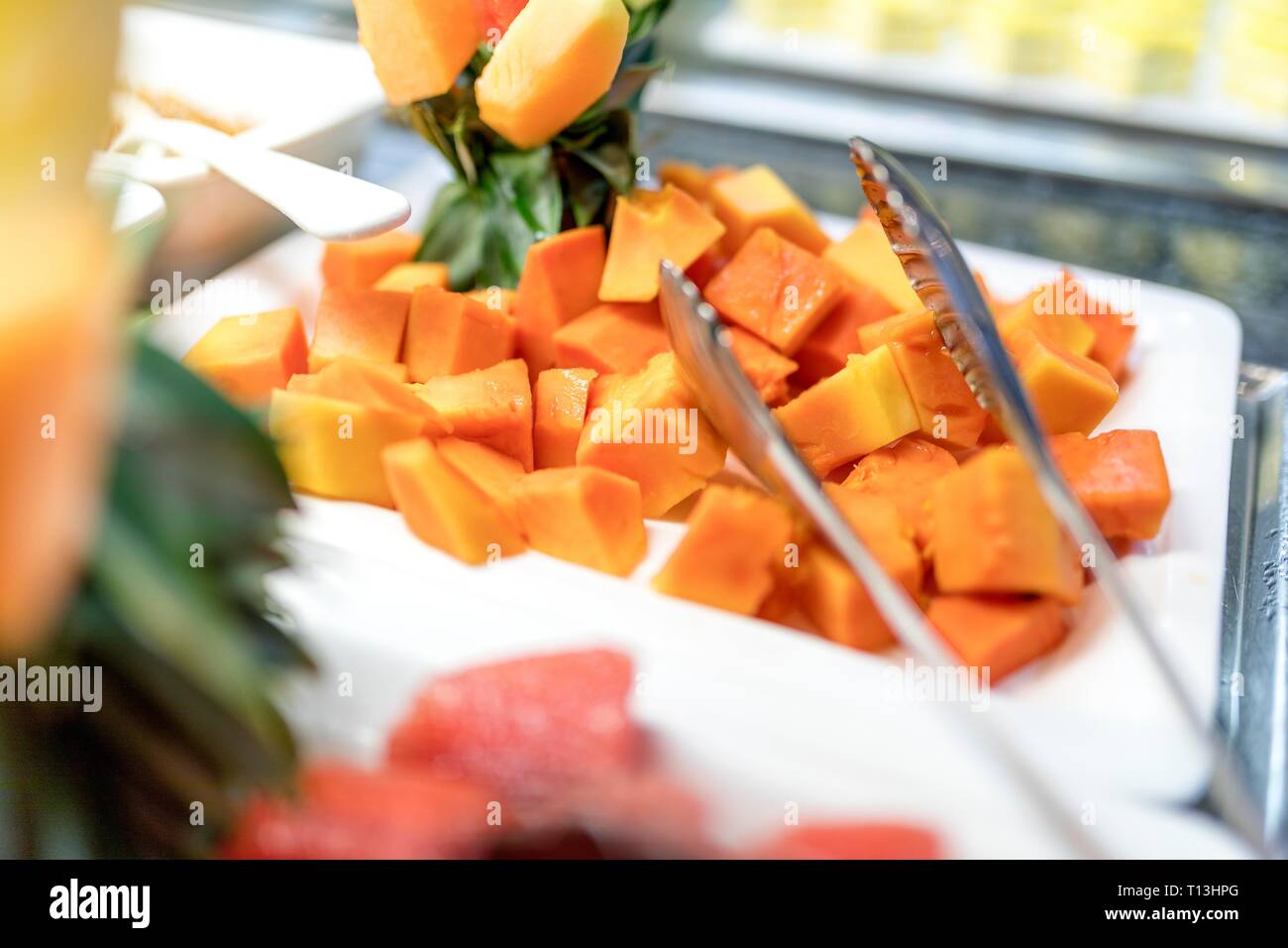 In der Nähe von frisch und lecker gewürfelte organische Mangofrucht Würfel auf ein Buffet mit Zangen. Stockfoto