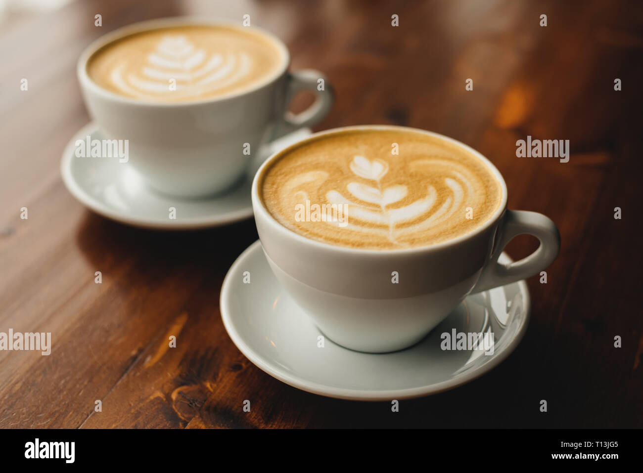 Zwei Tassen Cappuccino auf dem Holztisch. Stockfoto