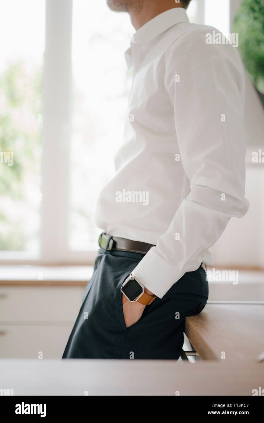 Unternehmer lehnen auf Küche Oberfläche mit den Händen in den Taschen Stockfoto