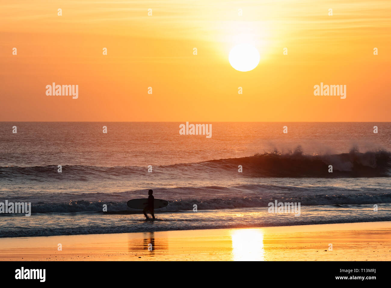Indonesien, Bali, Sonnenuntergang am Meer, Surfer am Strand Stockfoto