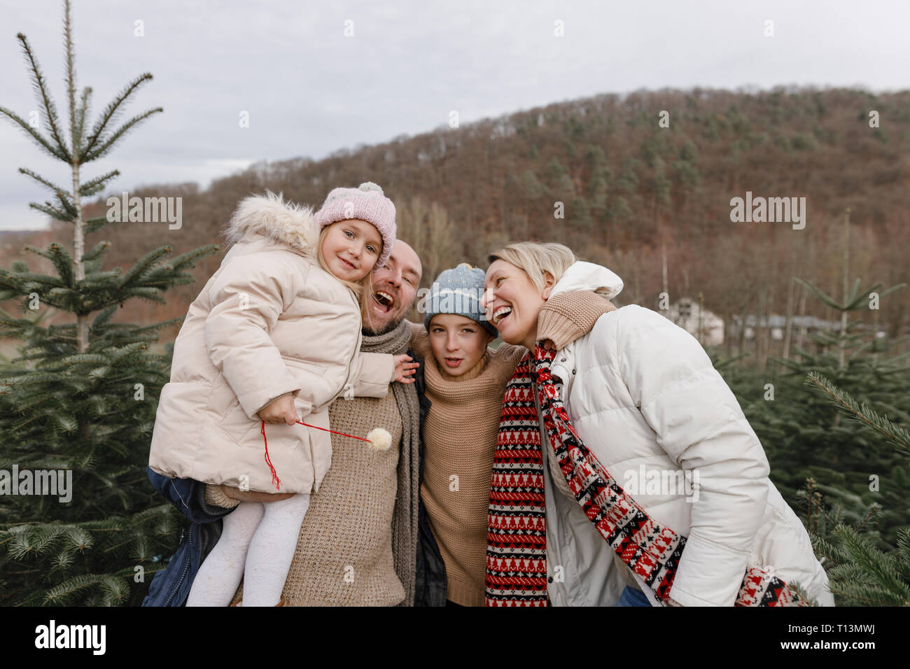 Portrait der glücklichen Familie mit zwei Kindern auf einem Weihnachtsbaum Plantage Stockfoto