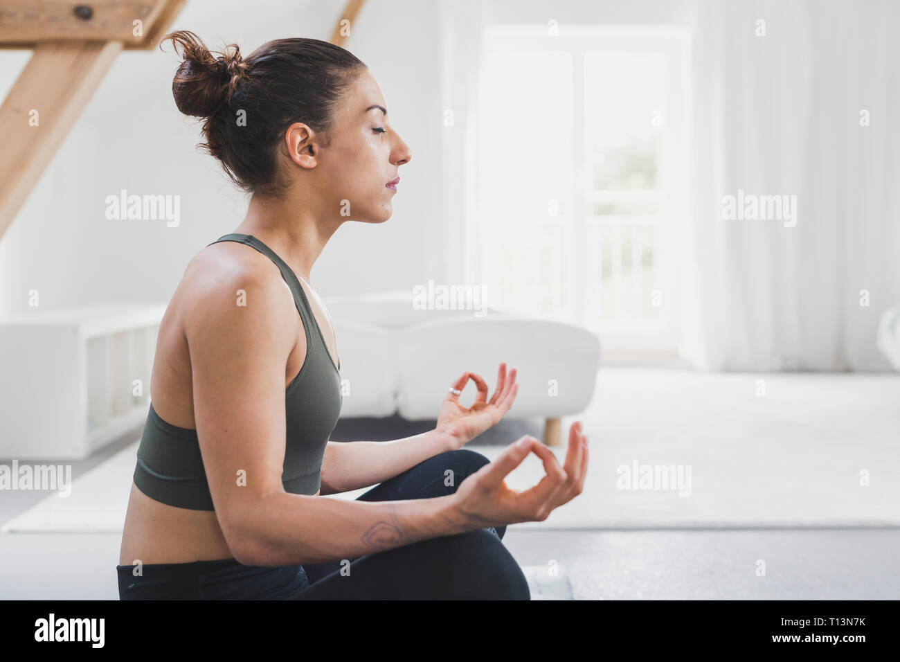 Frau sitzt mit Yoga Stockfoto