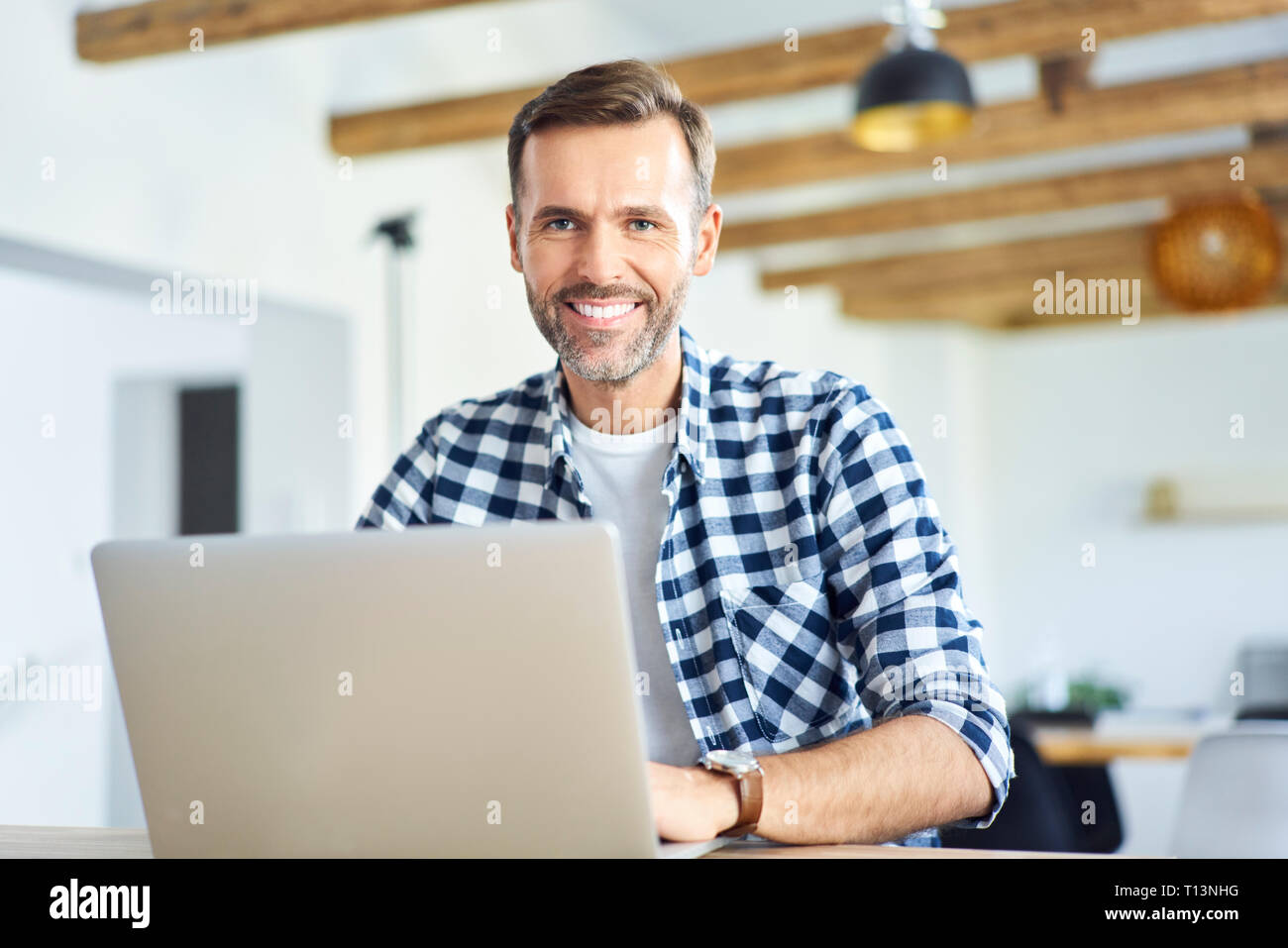 Porträt des Menschen Arbeiten von einem Remotestandort aus auf Laptop und Kamera Stockfoto