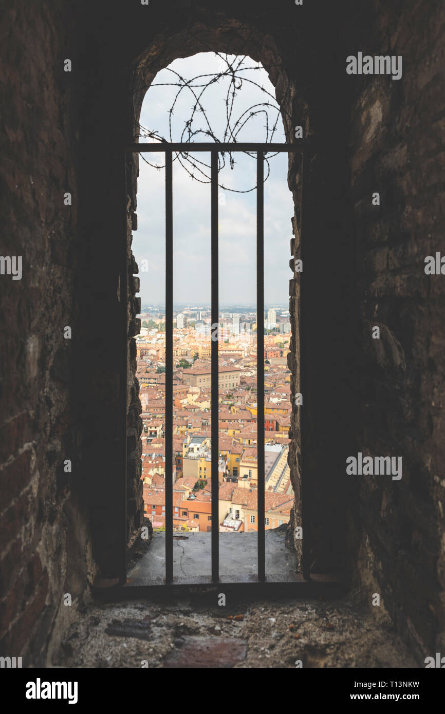 Italien, Bologna, Blick auf die Stadt durch Mauerwerk mit Metallgitter Stockfoto