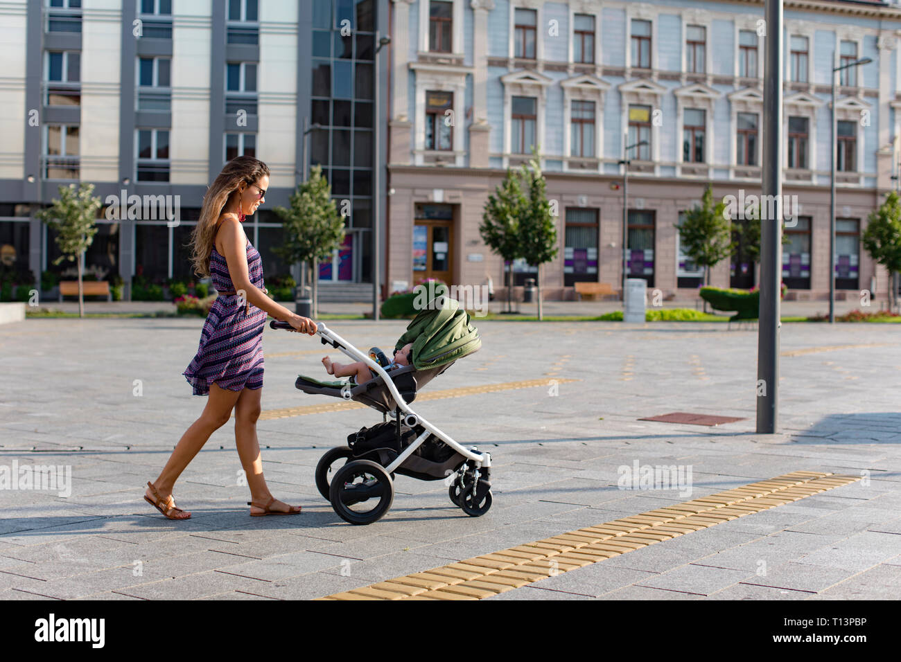 Mutter drücken Baby in einem Kinderwagen in der Stadt Stockfoto