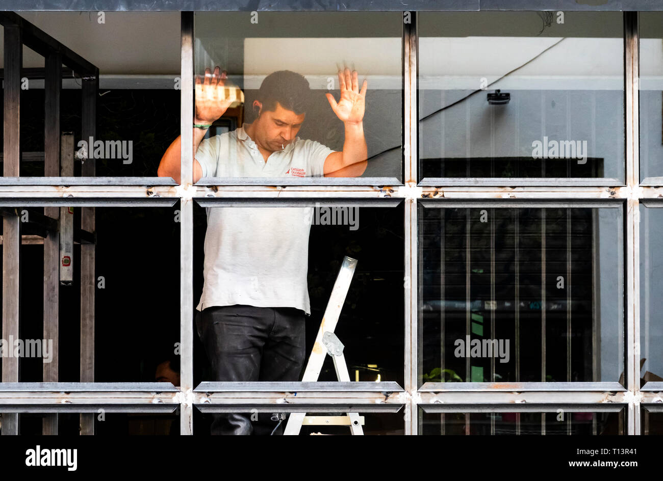 Arbeitnehmer gerade ein Glas Abschnitt in ein Schaufenster in Sevilla Stockfoto