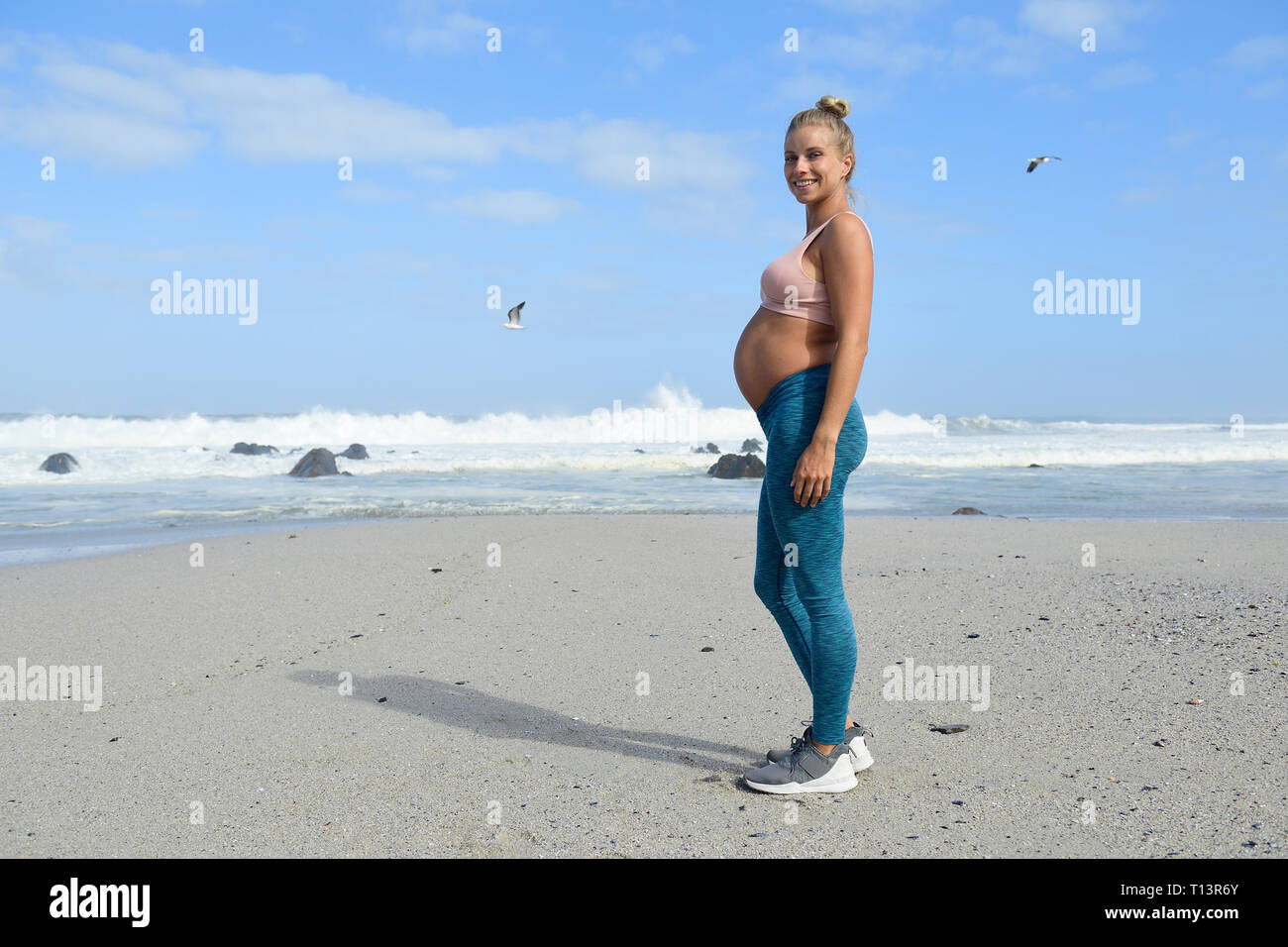 Aktive schwangere Frau am Strand Stockfoto