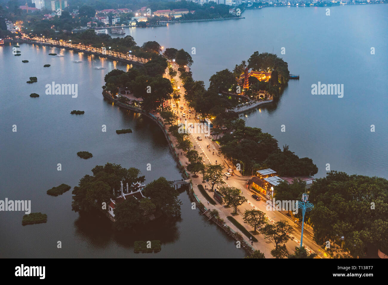 Vietnam, Hanoi, Panoramablick auf einer Straße zwischen zwei Seen in der Dämmerung mit Tran Quoc Pagode auf der rechten Seite Stockfoto