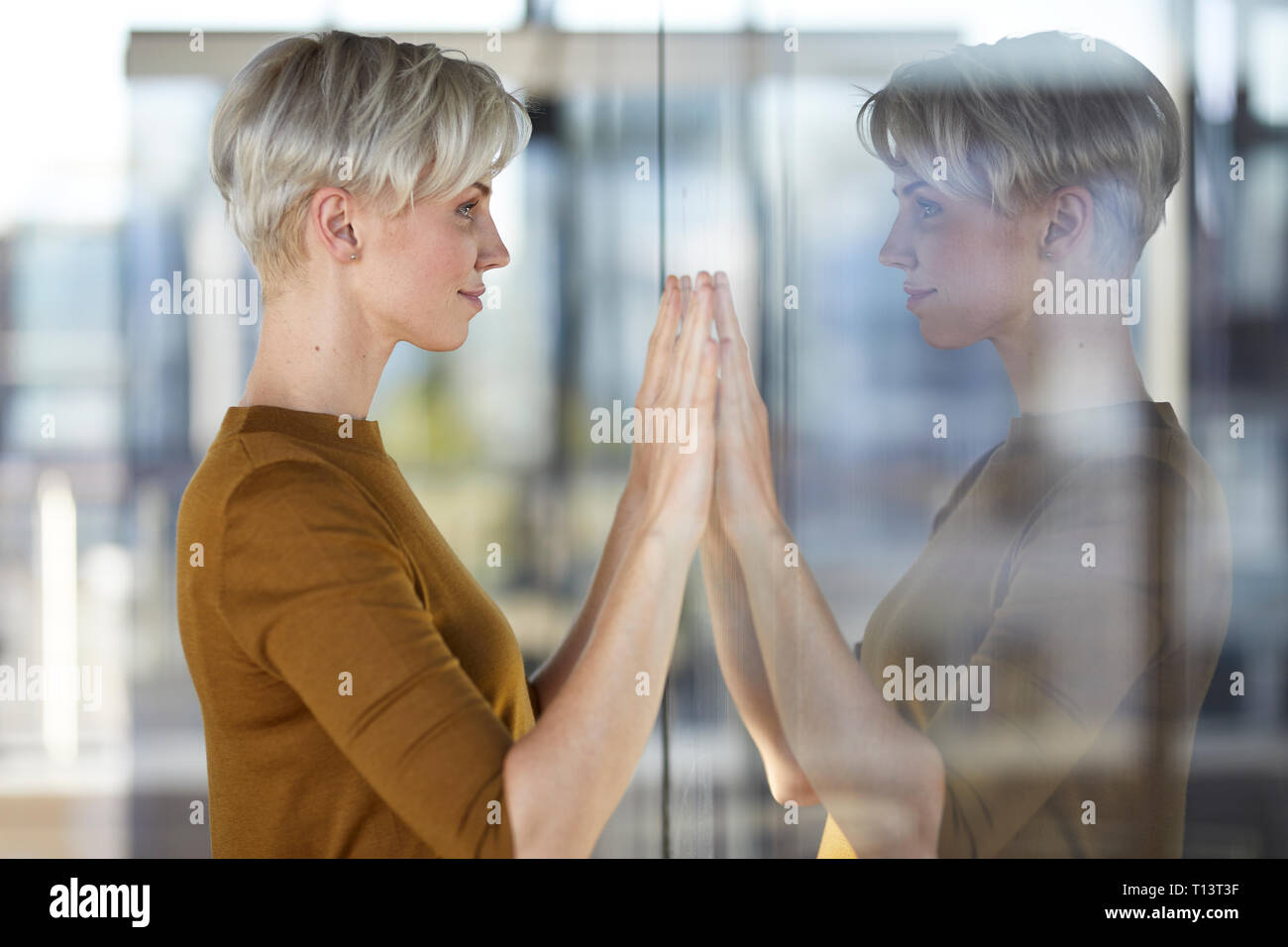 Frau im Fenster reflektiert Stockfoto