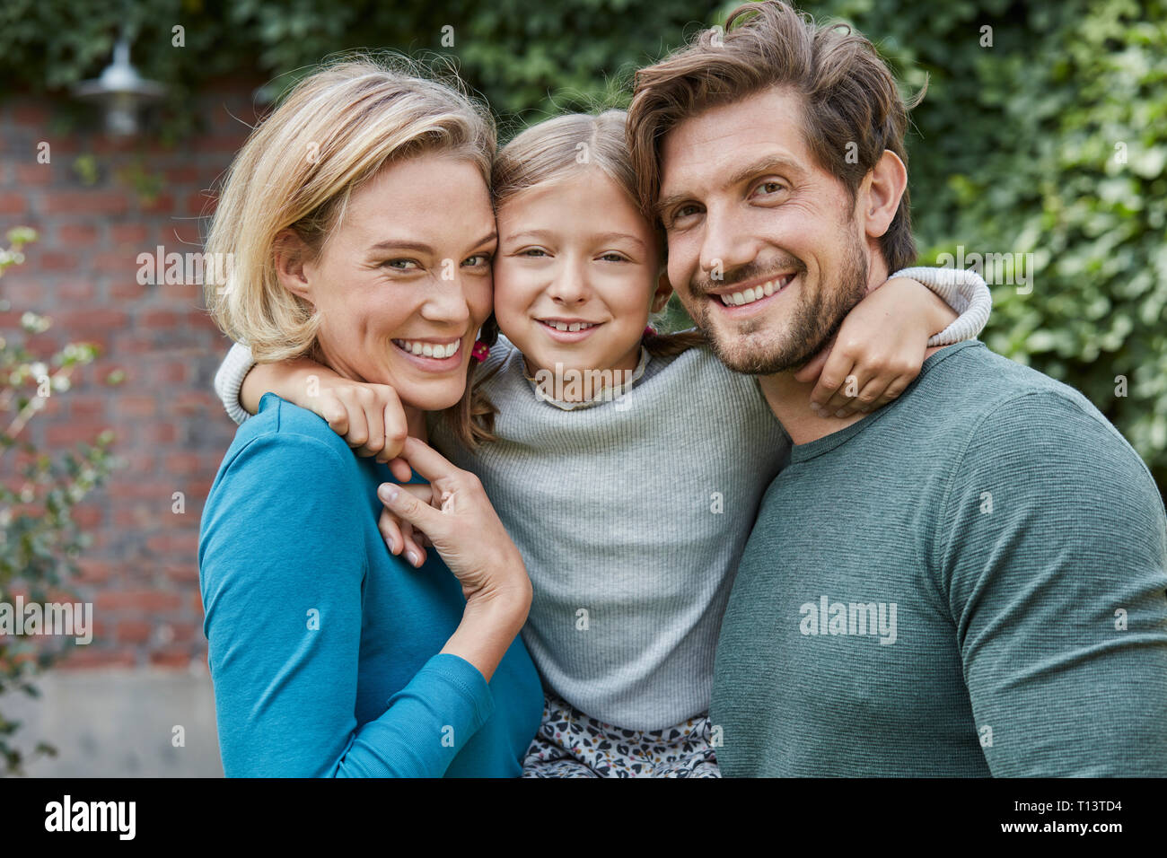 Portrait von Happy Family im Garten ihres Hauses Stockfoto