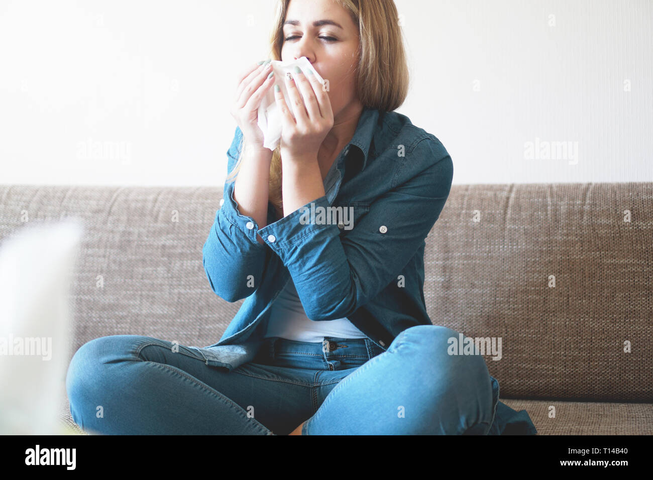 Portrait von ungesunden cute blonde Frau mit Serviette blasen Nase, sieht die Ursache der Allergie. Rhinitis, Kälte, Allergie Konzept Stockfoto