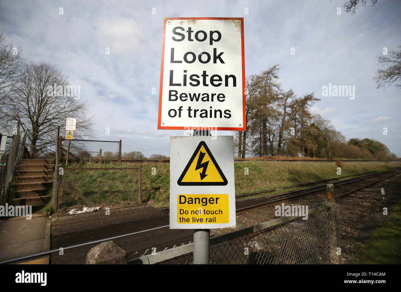 Allgemeine Ansicht eines Warnschild neben einer Fußgängerzone Bahnübergang in der Nähe von Worting Kreuzung in Hampshire mit einem Stop, Look, Zeichen anhören. Stockfoto