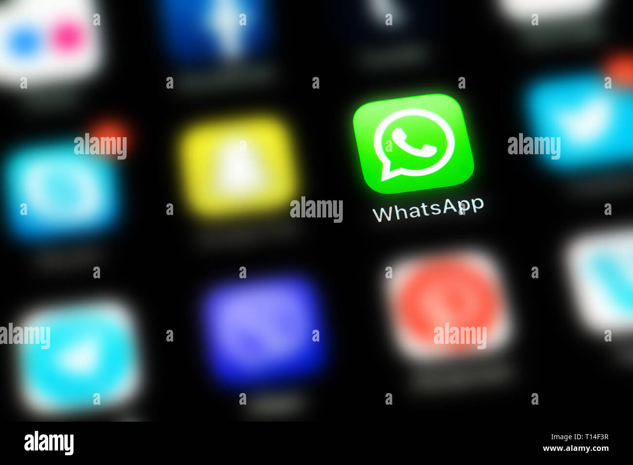 Apple iPhone X mit Symbolen von social media WhatsApp und anderen verwischt Anwendung auf einem schwarzen Bildschirm. Social media Icons. Soziales Netzwerk Stockfoto