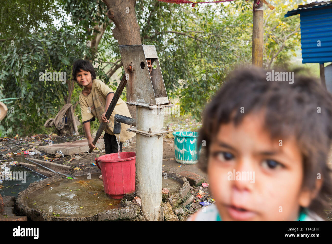Kleine Kinder in Indien. Agra Arbeiten: Kinder nehmen Wasser auf die Spalte Stockfoto