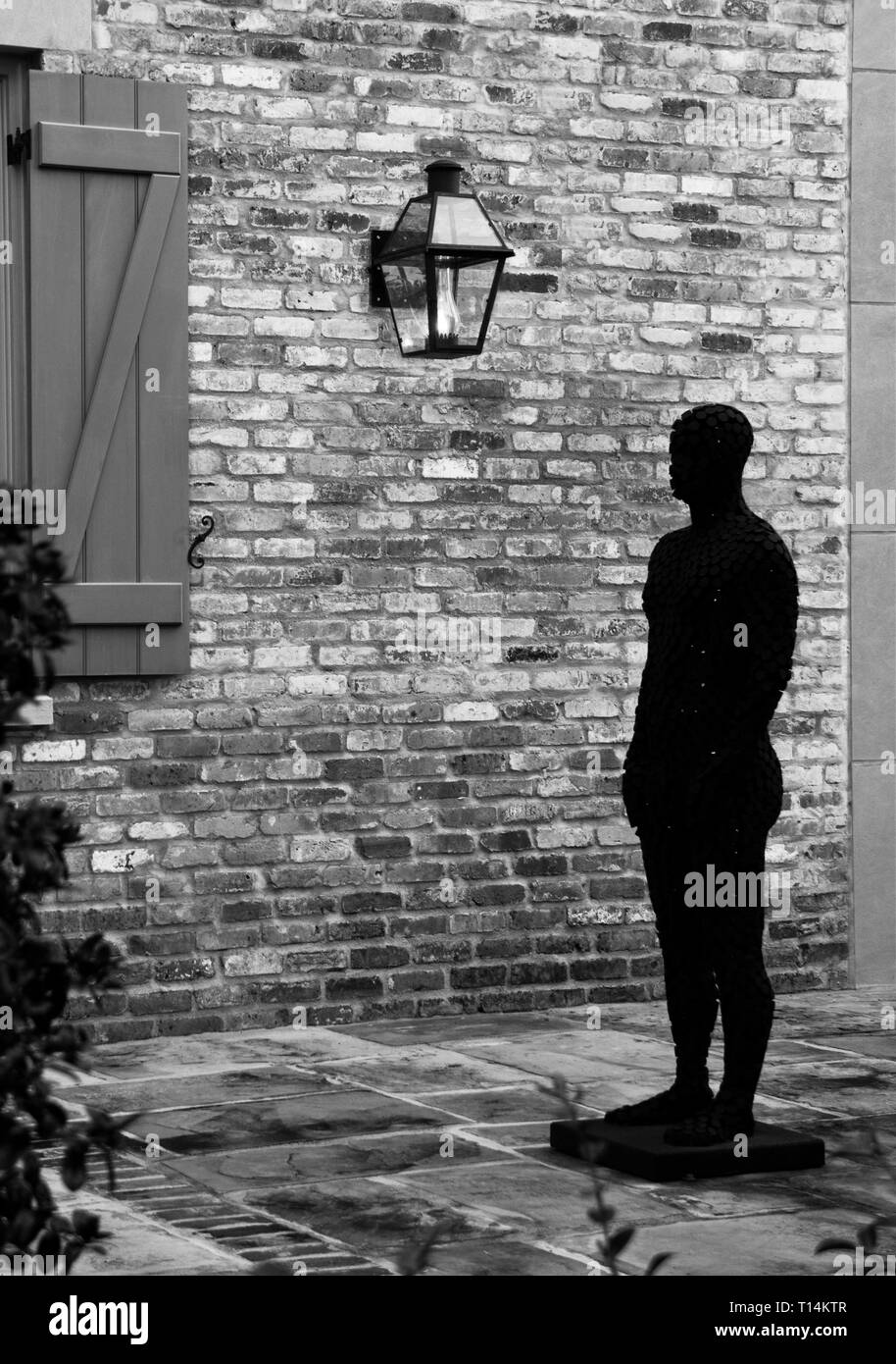Skulptur eines männliche Figur in einem New Orleans Innenhof. Stockfoto