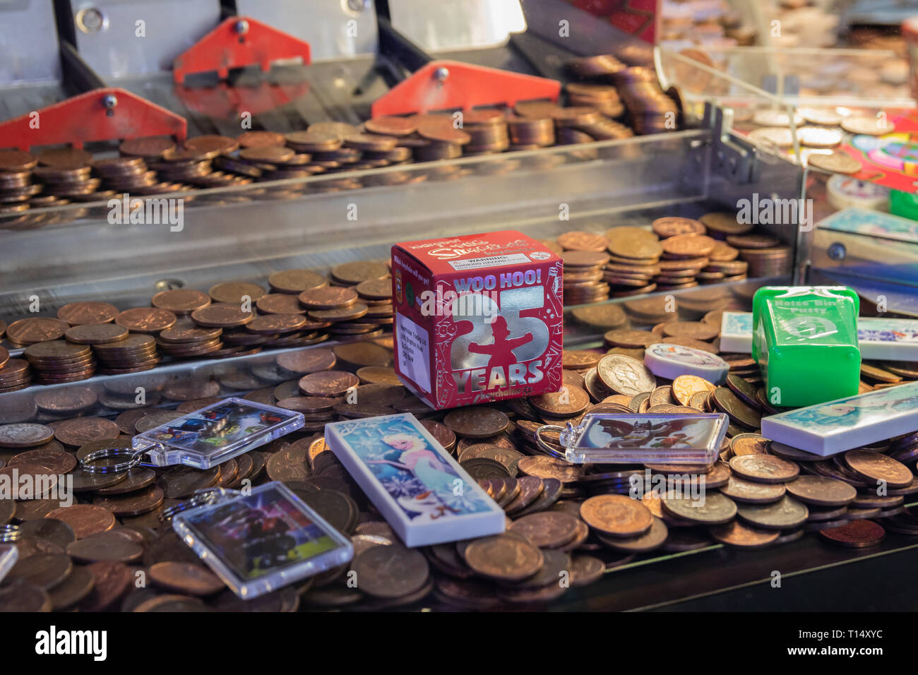 Nahaufnahme von Twp pence Stücke in einer Münze in der Arcade Maschine schieben Stockfoto