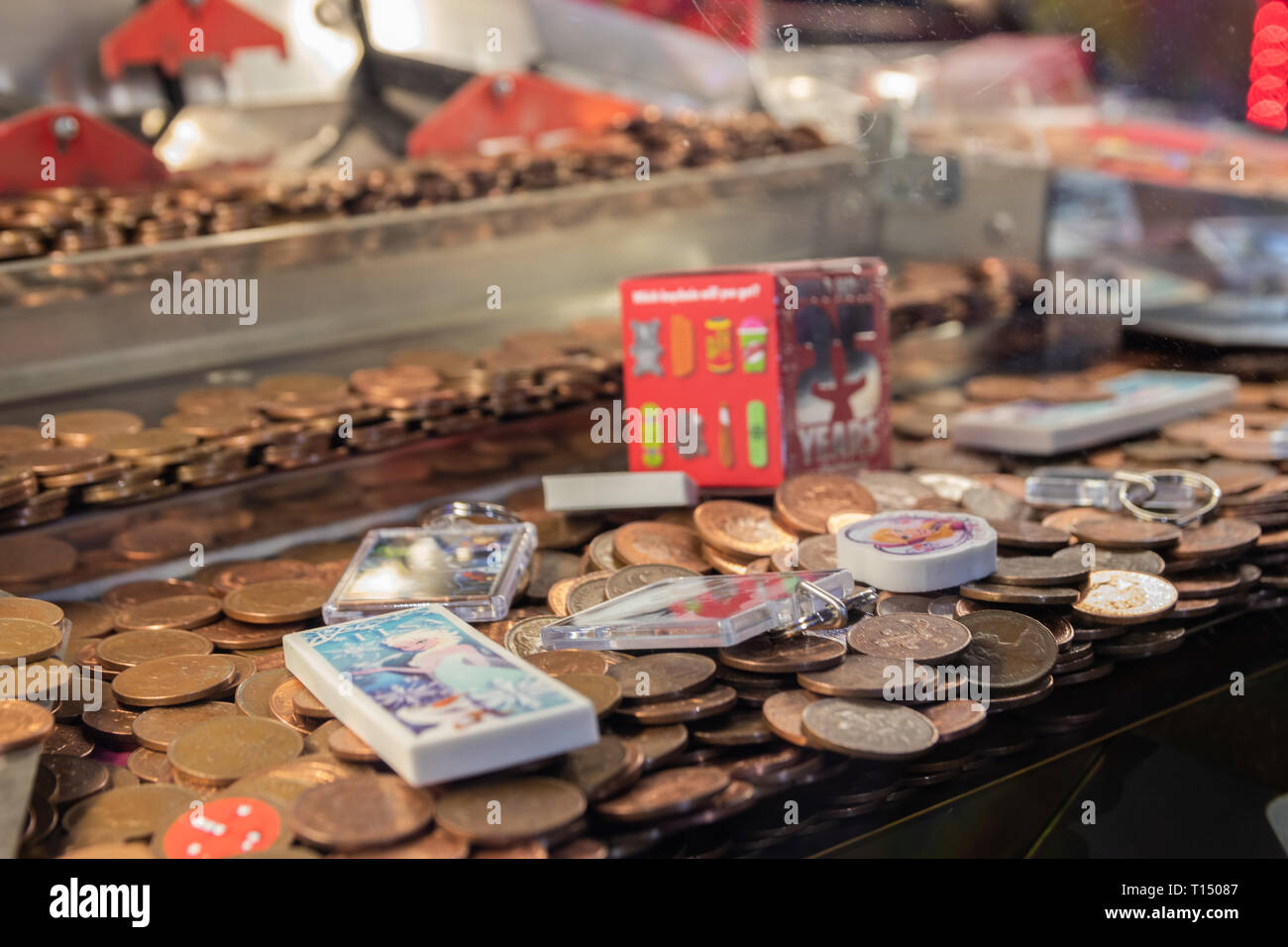 Nahaufnahme von Twp pence Stücke in einer Münze in der Arcade Maschine schieben Stockfoto