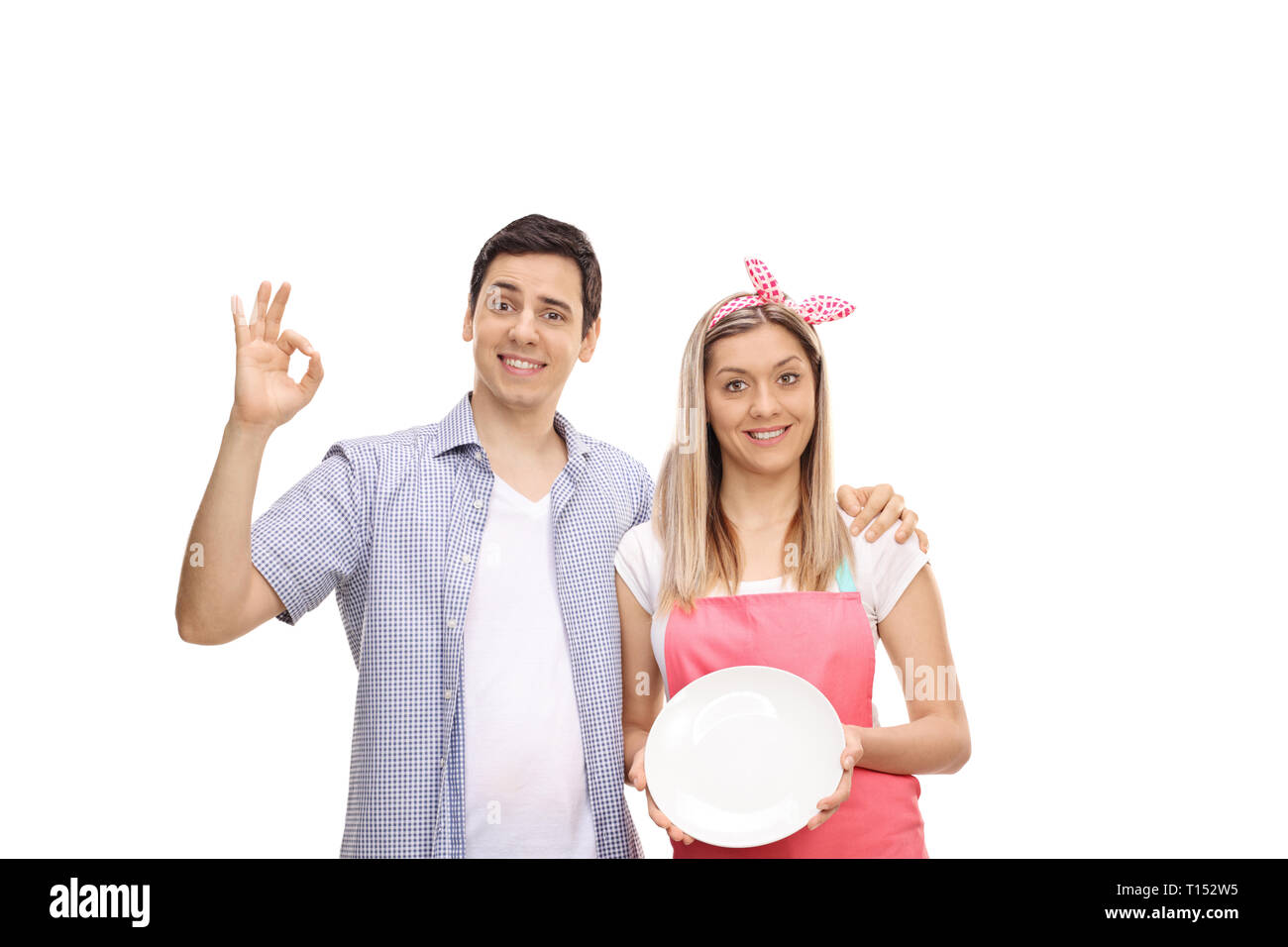 Junges Paar mit einem sauberen Teller auf weißem Hintergrund Stockfoto