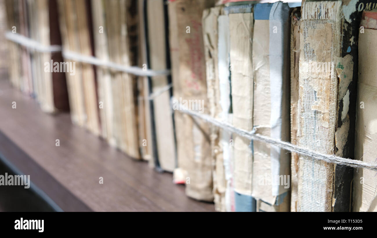 Close-up alte Bücher mit einem Seil auf hölzernen Regal in der Bibliothek oder im Archiv gebunden Stockfoto
