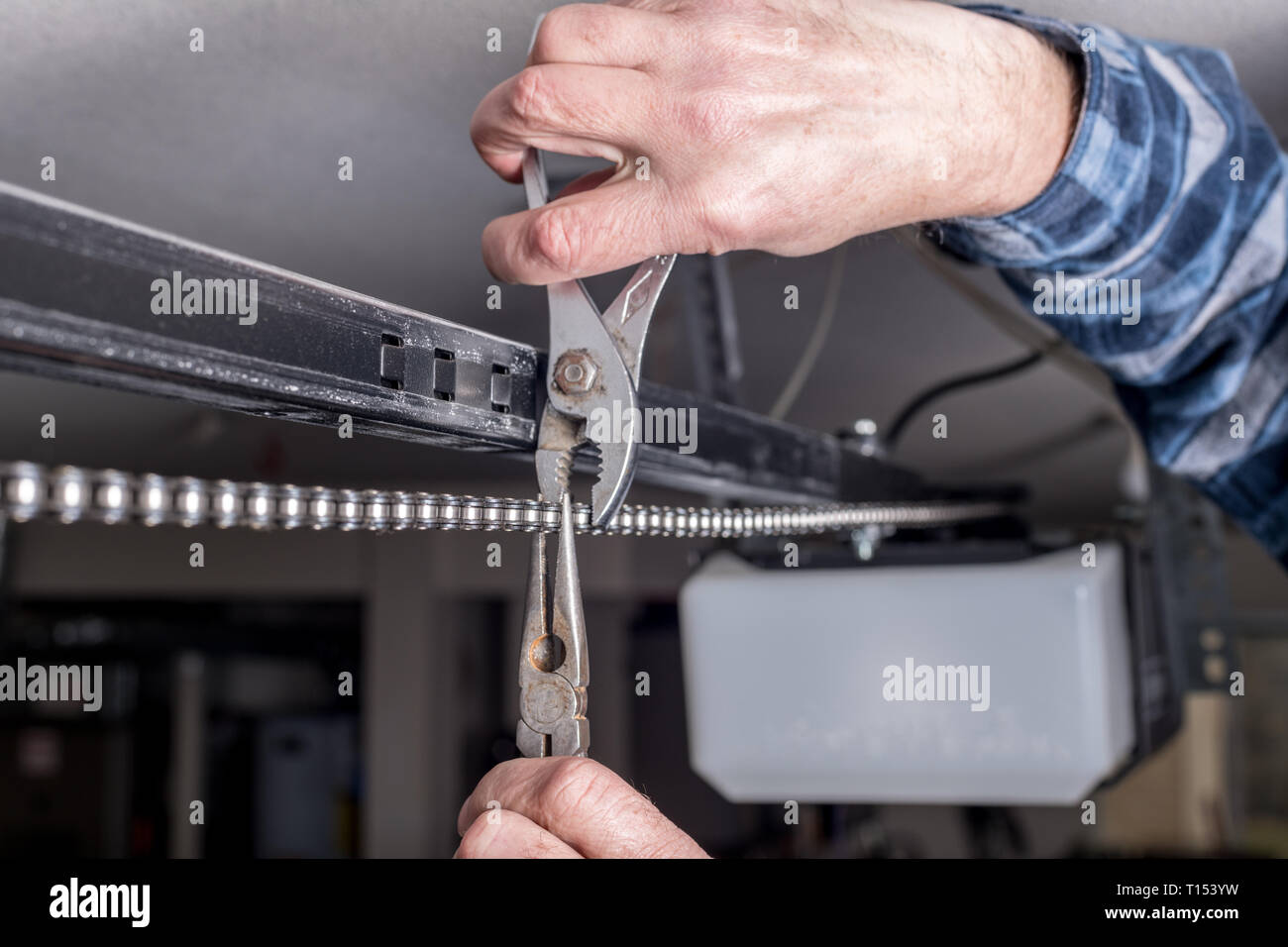 Instandhaltung erfolgen eines Home Garagentor Kette mit plyers  Stockfotografie - Alamy