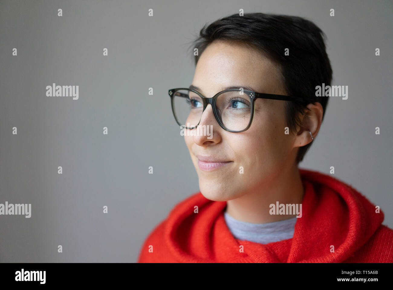 Porträt eines lächelnden jungen Frau mit kurzen Haaren, Brille Stockfoto