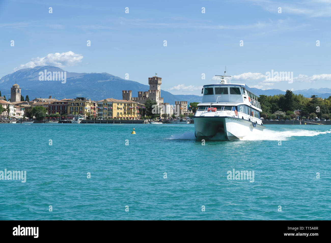Sirmione, Italien - 07 August 2017: Touristische Schiff am Gardasee. Panorama von Sirmione, Caligero Schloss und die Berge im Hintergrund. Stockfoto