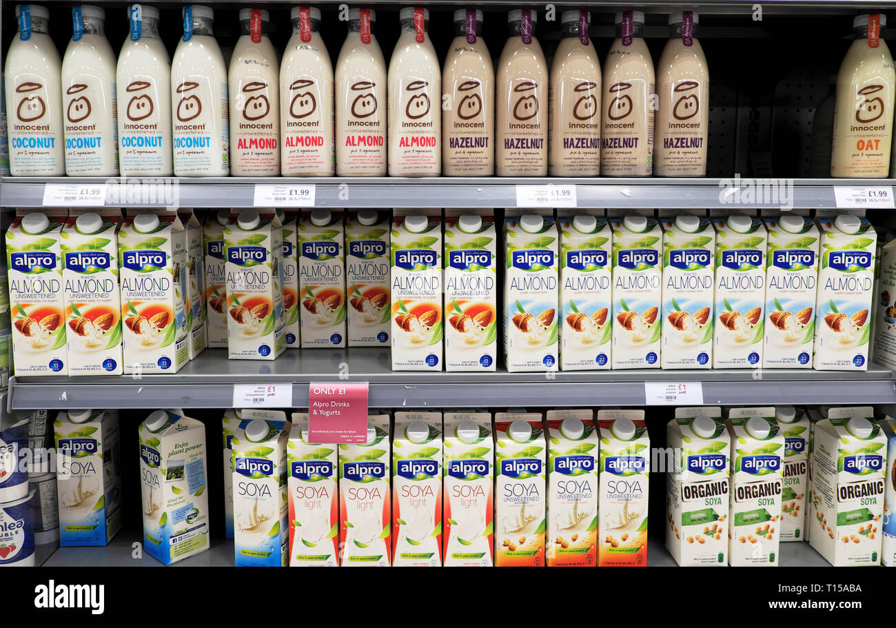Eine Vielzahl von milchfreien veganen Milchalternativen schachtelt Flaschen auf einem Kühlregal im Waitrose Supermarkt in London England UK KATHY DEWITT Stockfoto