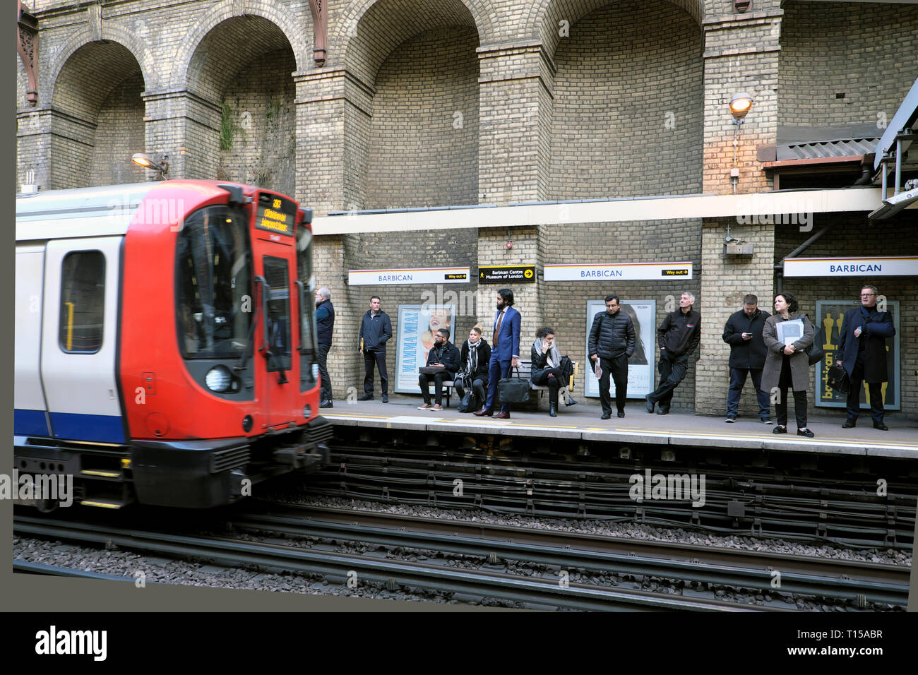 Oberirdische u-Zug nähert sich Barbican Station Plattform mit Passagiere warten, Vorstand der Schlitten London England UK KATHY DEWITT zu Stockfoto
