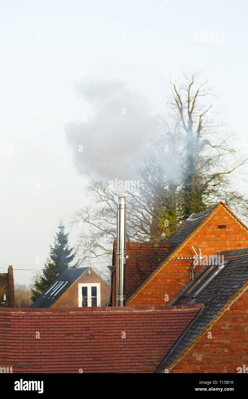 Buckingham, Großbritannien - 11 December 2018. Eine heimische Biomasse Rauchrohr Rauch Dämpfe in die Umgebung Stockfoto
