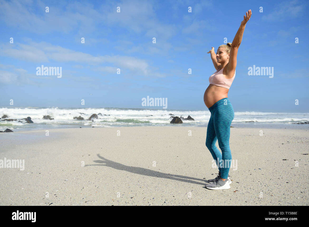 Glückliche schwangere Frau am Strand Stockfoto