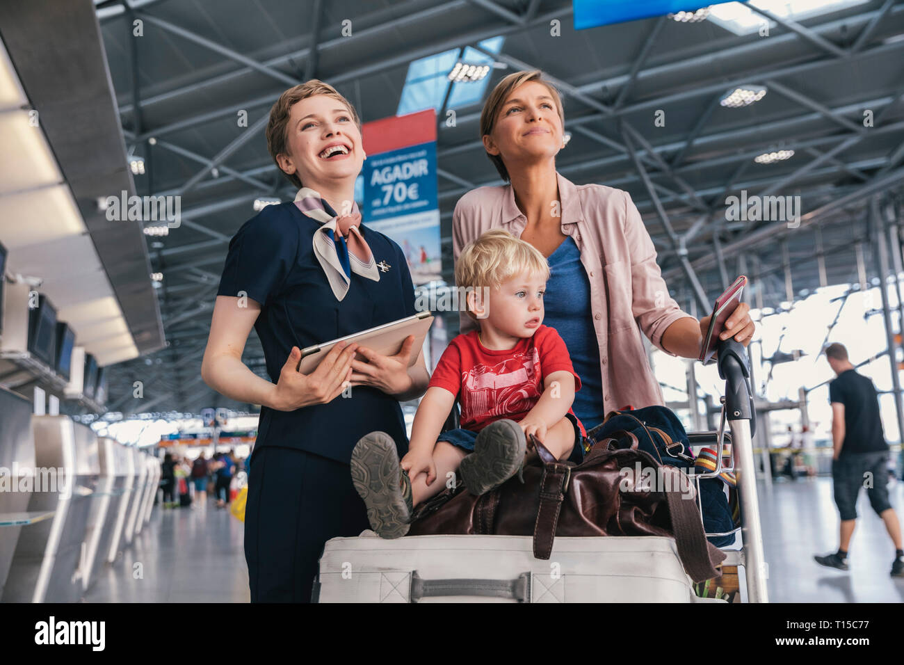 Happy airline Mitarbeiter mit Mutter und Kind am Flughafen Stockfoto