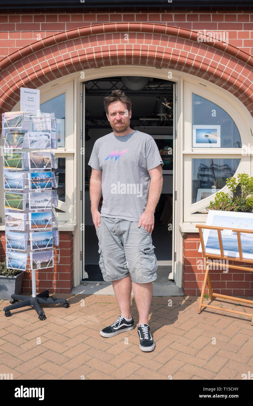 Brighton und Hove Meer Meer Bögen Ladenbesitzer in der Tür zu Ihrem Ladengeschäft stehen in der Sonne in einem touristischen Ort Stockfoto