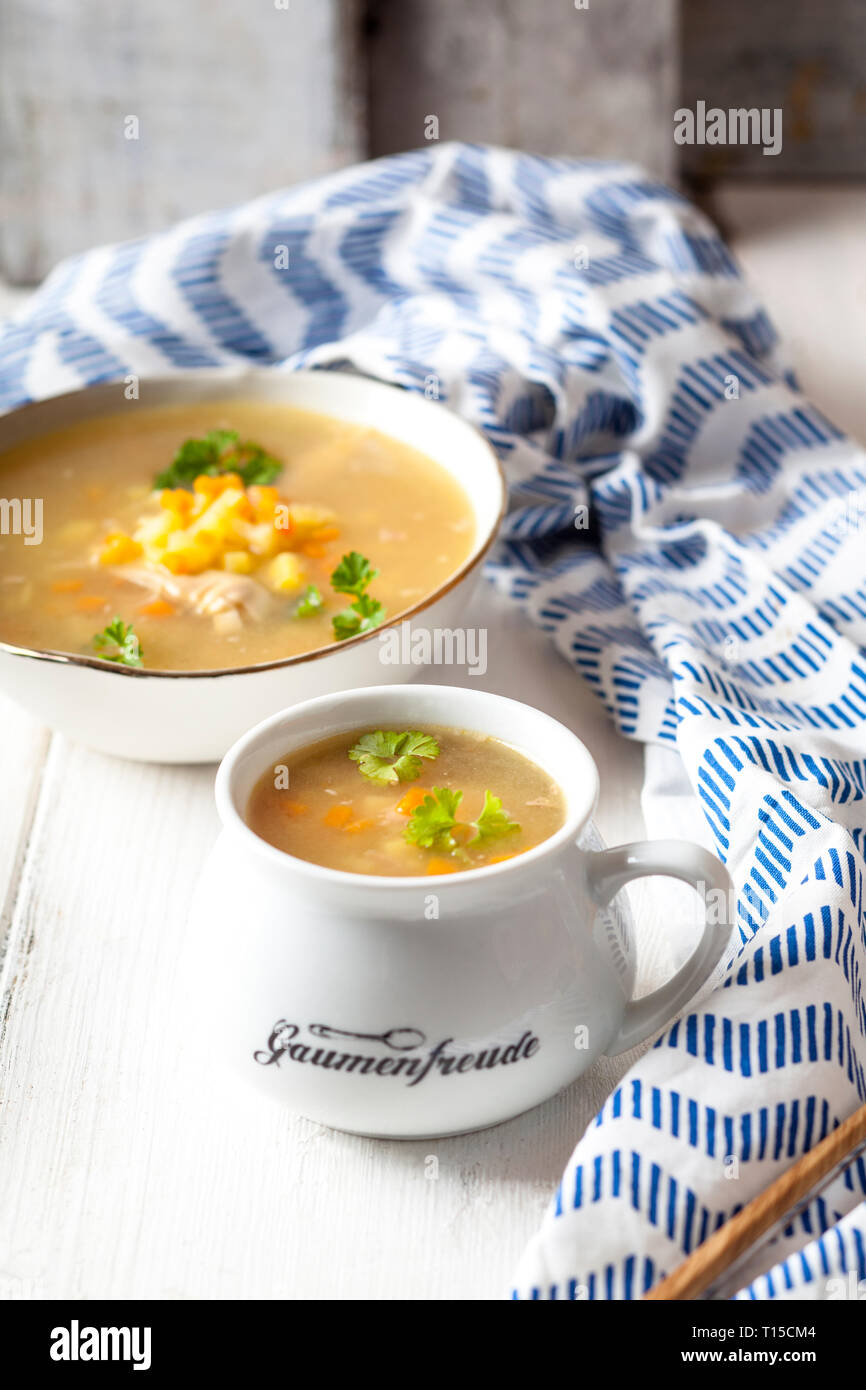 Schalen mit hausgemachter Hühnerbrühe mit Kartoffeln, Karotten und Petersilie Stockfoto