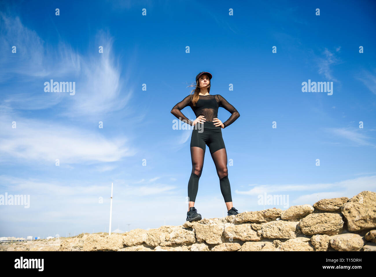 Zuversichtlich sportliche Frau, die auf Stein Wand Stockfoto