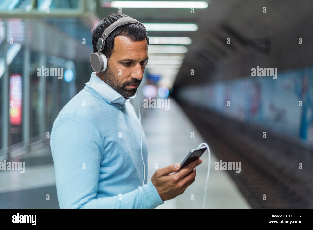 Geschäftsmann mit an der Metrostation smartphone Stockfoto