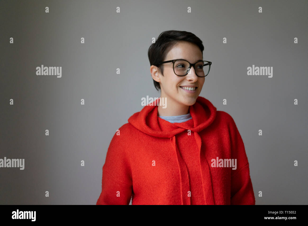 Porträt eines lächelnden jungen Frau mit kurzen Haaren, Brille Stockfoto