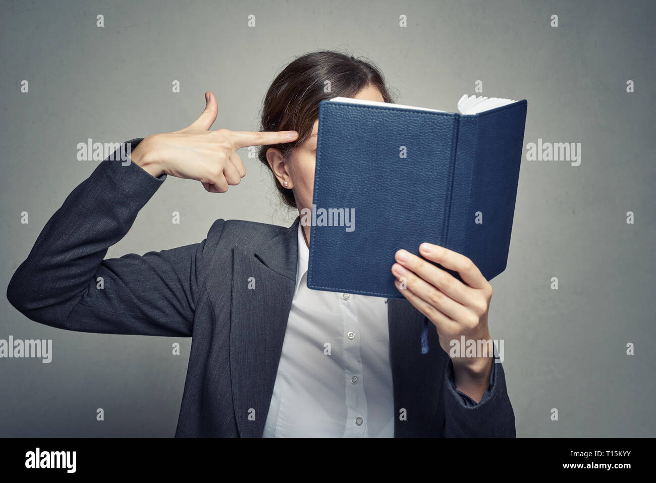 Business Frau in weißer Bluse und Anzug zeigen Geste schießen und töten sich selbst Stockfoto
