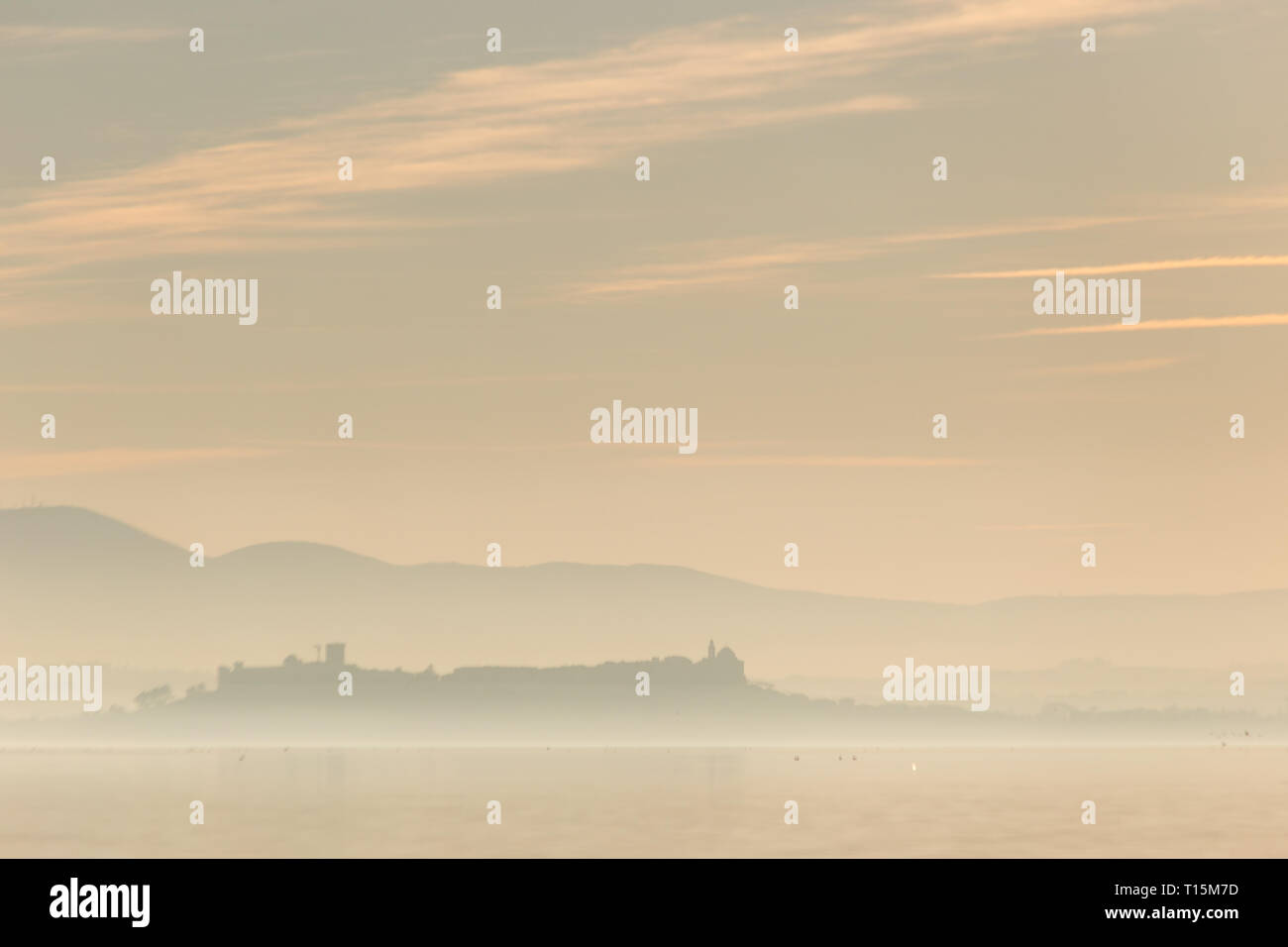 Schönen Blick auf den Trasimenischen See bei Sonnenuntergang mit Vögel auf dem Wasser und Castiglione del Lago Stadt Stockfoto