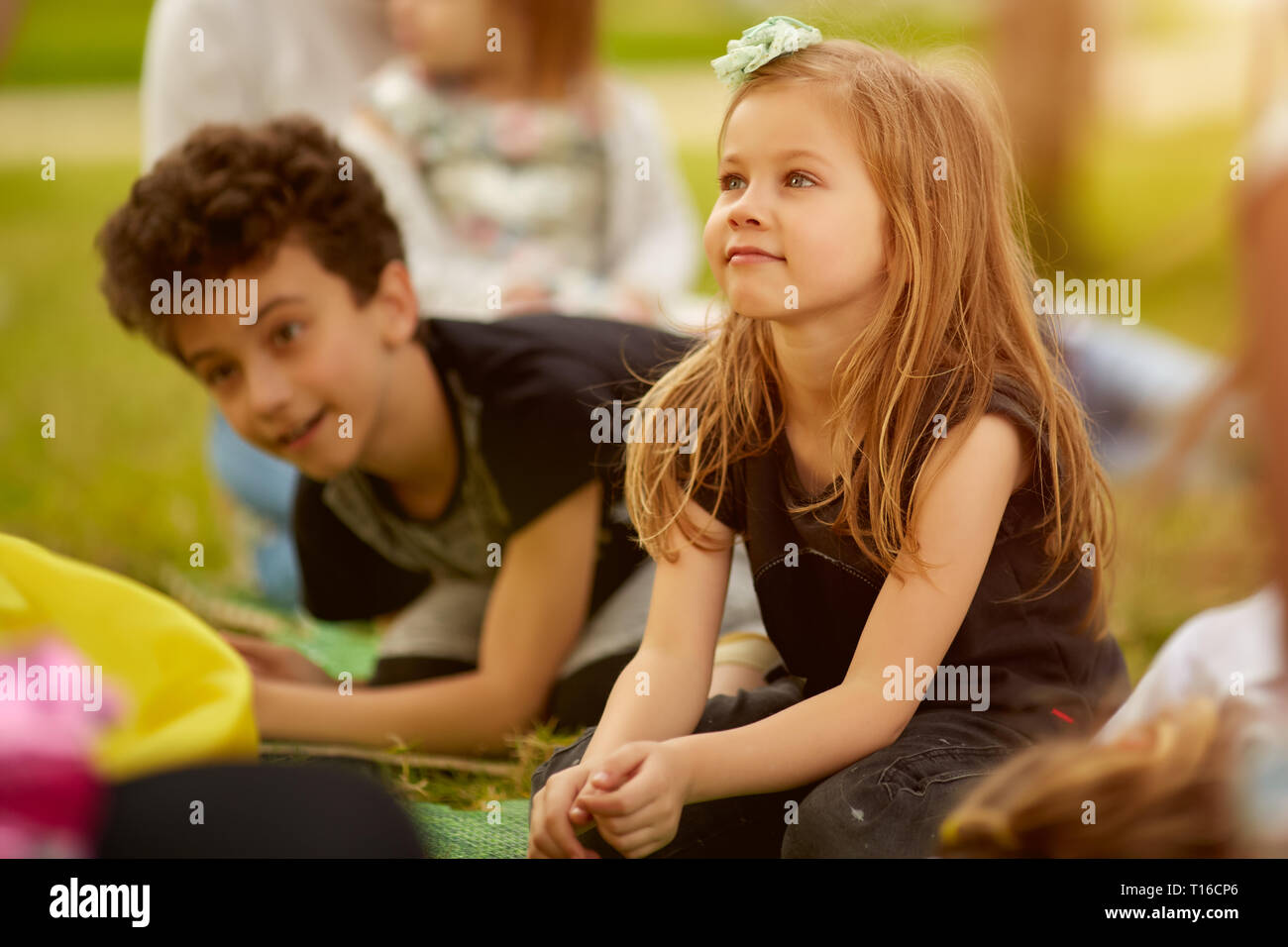 Bruder und Schwester spielen sitzen auf dem Rasen im Park im Freien Stockfoto