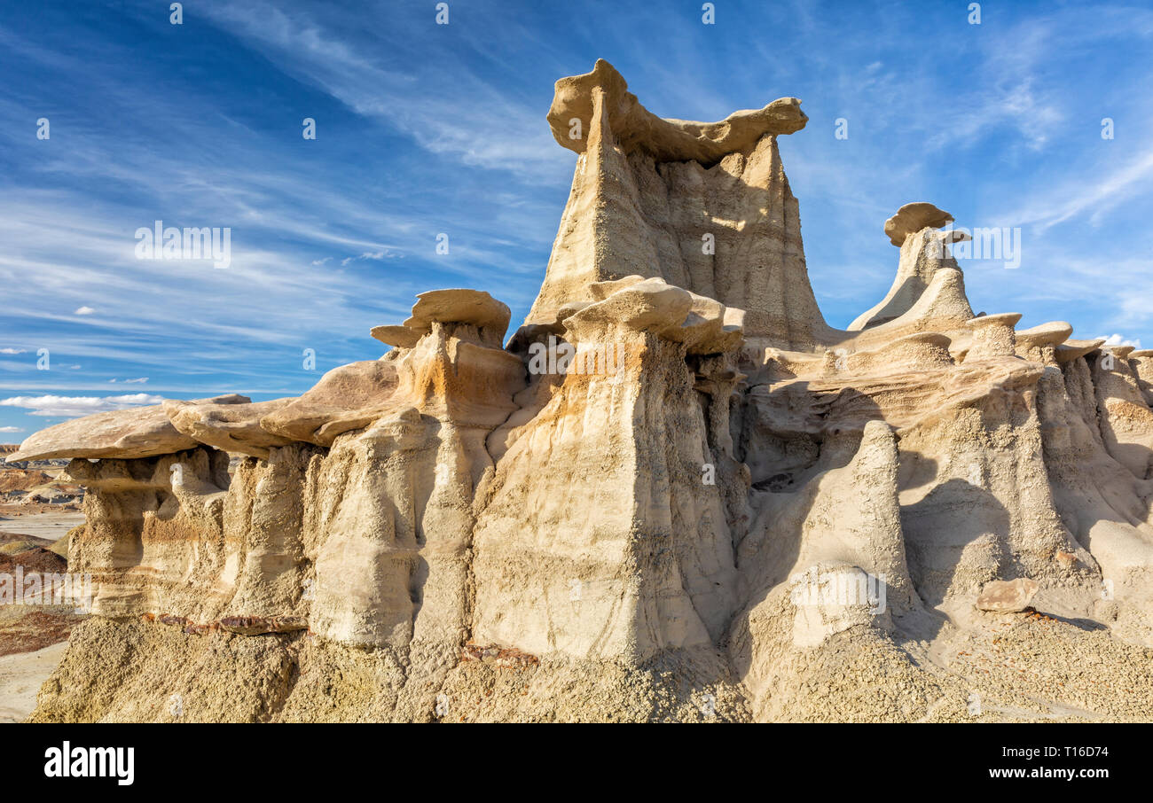 Zwei Schichten von Sandstein hoodoos mit dramatischen Wolken im blauen Himmel im BIsit/De-Na-Zin WIlderness in New Mexiko. Stockfoto
