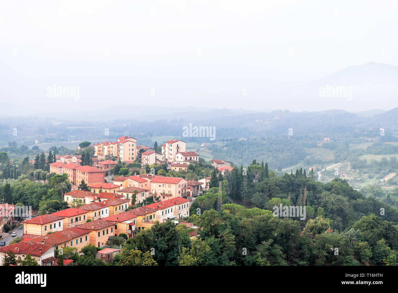 Chiusi Dorf Stadtbild in der Toskana Italien mit orange rot Dach tile Häuser am Berg Land und sanften Hügeln mit Nebel und Dunst Nebel Stockfoto