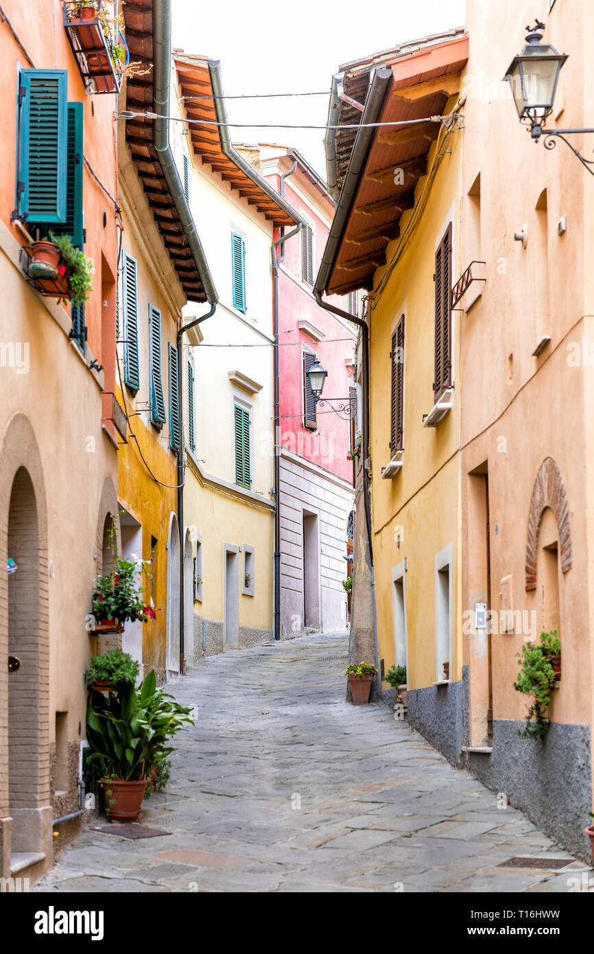 Chiusi, Italien Straße schmale Gasse in der kleinen historischen Stadt Dorf in Umbrien vertikale Ansicht während der sonnigen Tag mit orange gelb hell leuchtenden bunten w Stockfoto