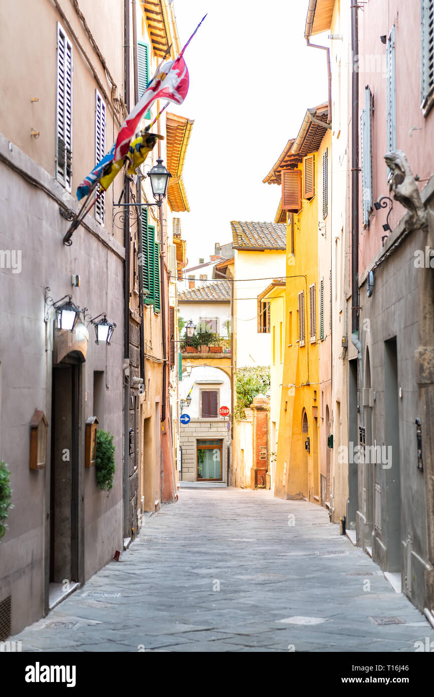 Chiusi, Italien leere Straße in kleinen Stadt Dorf in Umbrien Toskana schmalen vertikalen Ansicht bei Tag mit orange rosa gelb hell leuchtende, brillante Farben Stockfoto