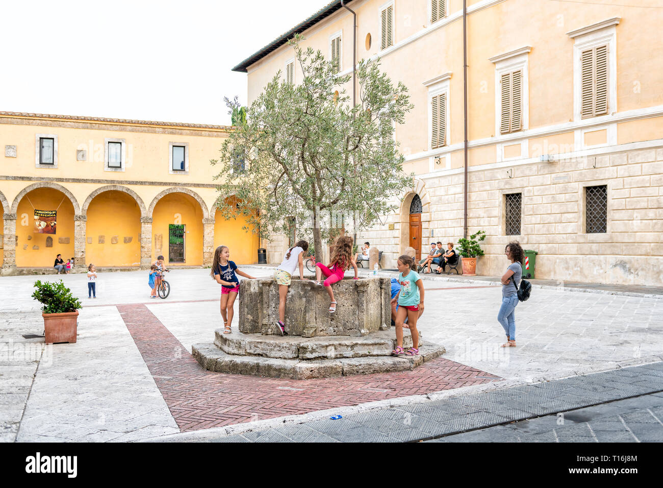 Chiusi, Italien - 25 August, 2018: Straße Platz der Kirche in der kleinen Stadt Dorf in Umbrien bei Tag mit Kindern Menschen Kinder, die von den römischen Zisterne Stockfoto
