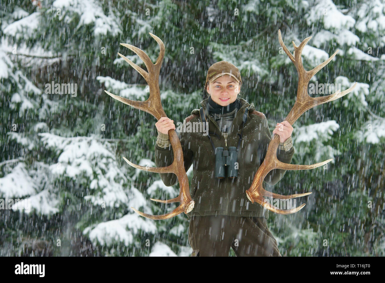 Eine glückliche Frau, schön mit Hirsch Geweih. Die Arbeit im Wald. Jagd Trophäe. Stockfoto