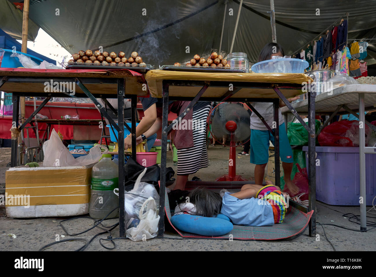 Berufstätige Mutter. Kind schläft unter ihrer Mütter Garküche. Thailand, Südostasien Stockfoto