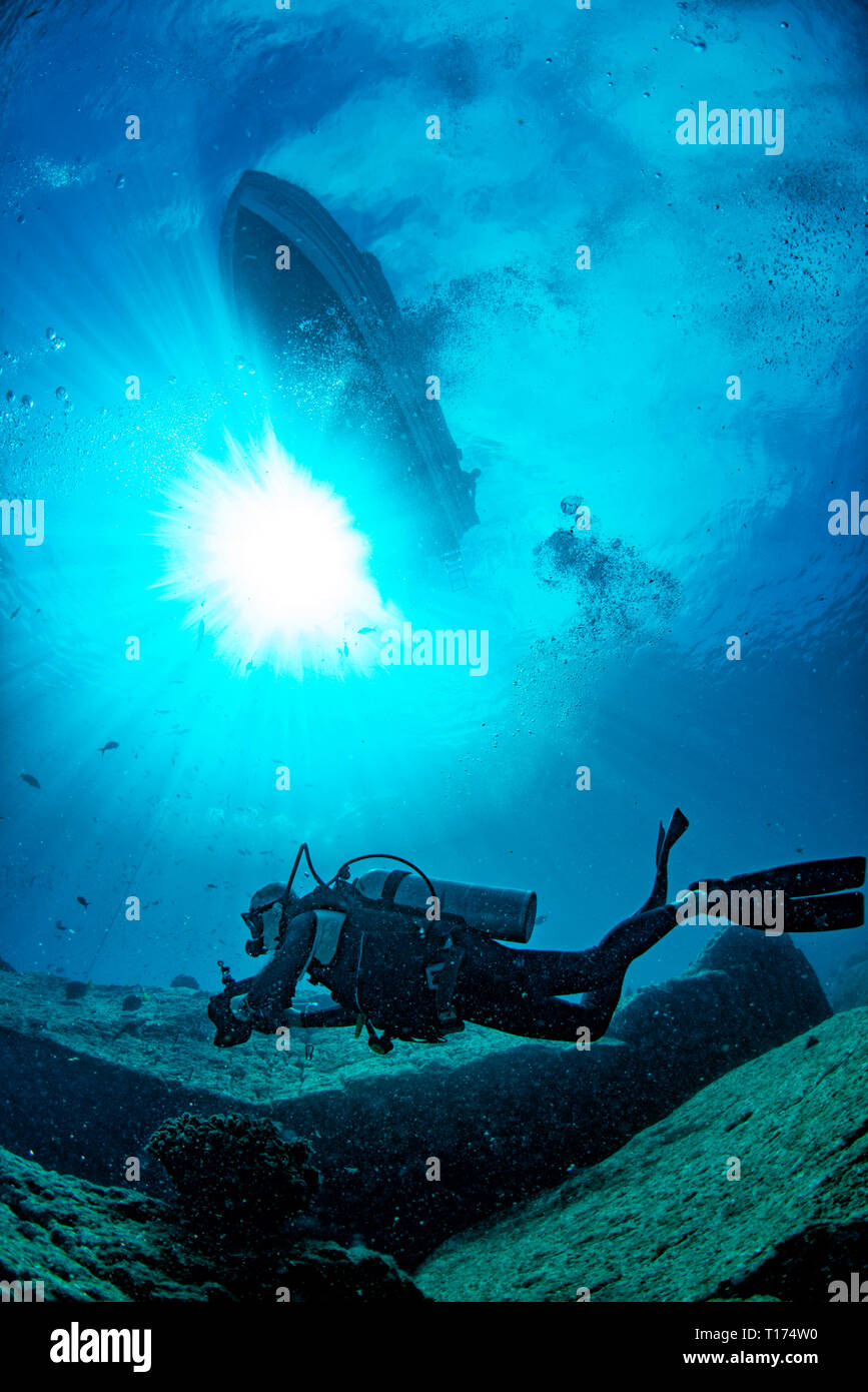 Boot von Unterwasser mit Sonnenstrahlen und Scuba diver Stockfoto