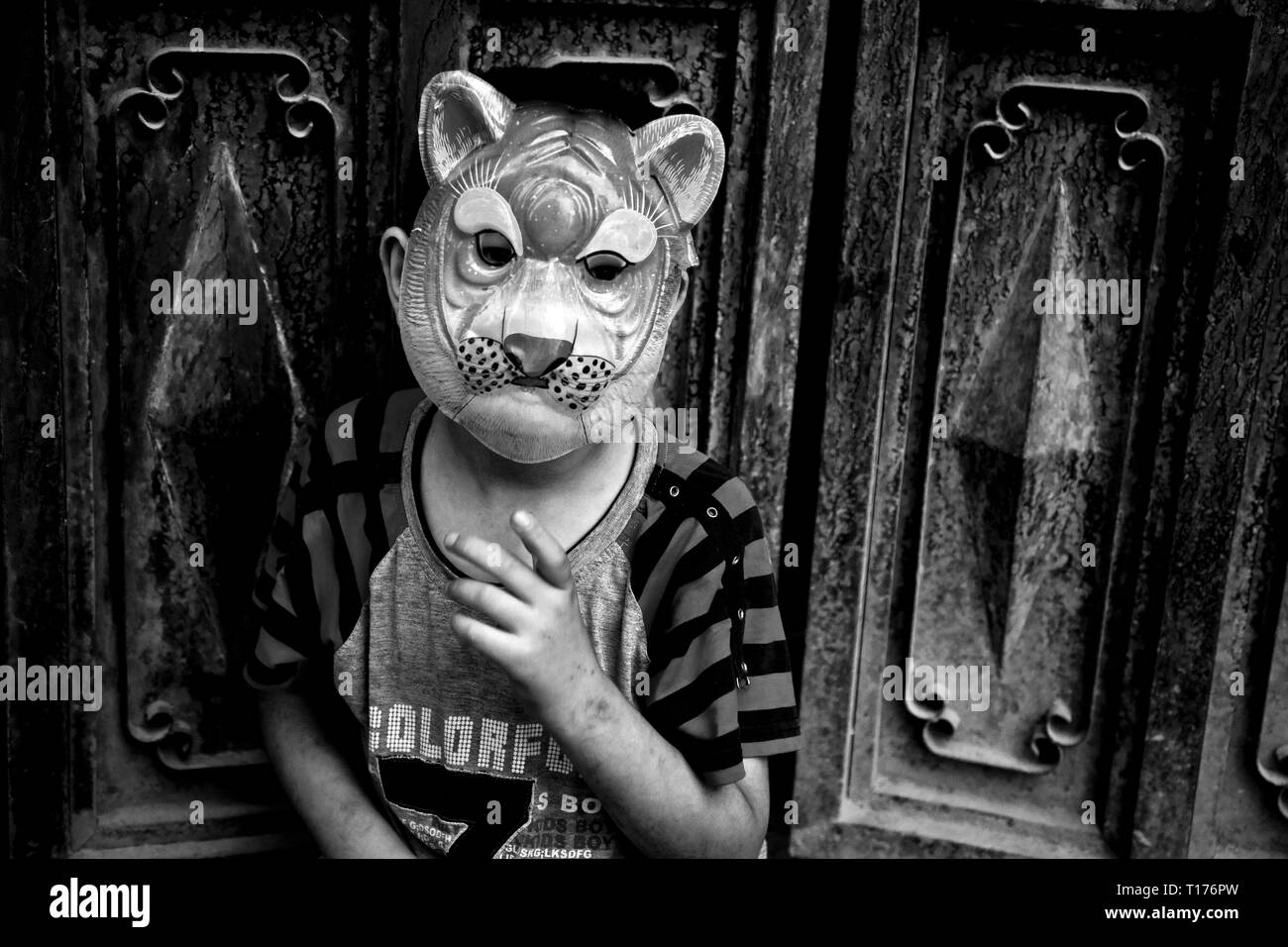 Kind mit Maske auf dem Kopf, Kashgar, Autonome Region Xinjiang, China. Stockfoto