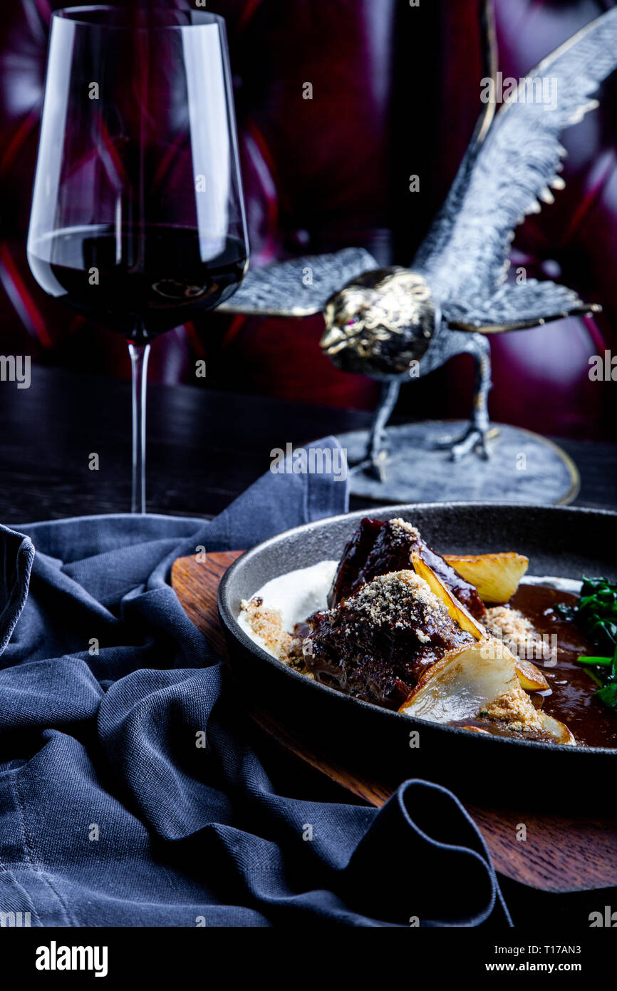 Geschmorte Kalbsbäckchen in Rotwein, serviert mit Kartoffelpüree. Foto für Menü. Stockfoto