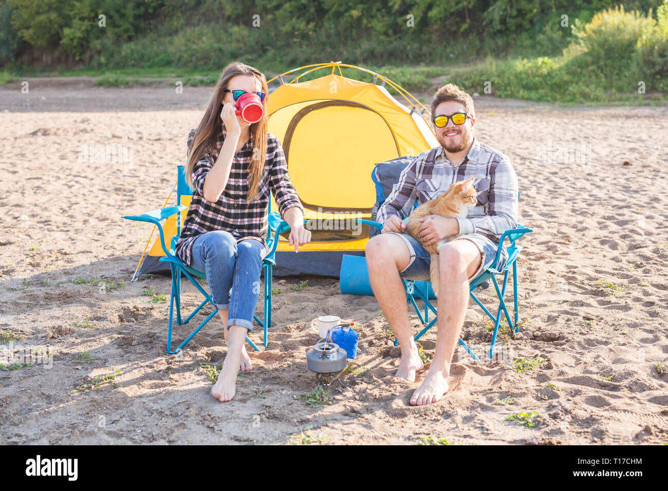 Leute, Sommer Tourismus und Natur Konzept - Junges Paar Tee trinken, in der Nähe von Zelt Stockfoto